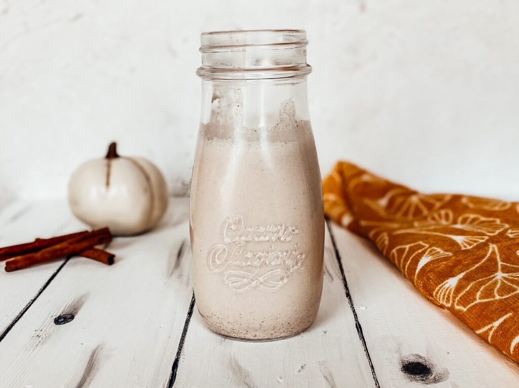 pumpkin spice coffee creamer in a glass jug on a white table