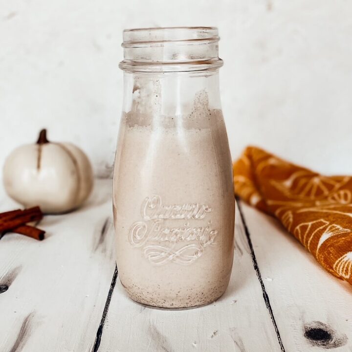 pumpkin spice coffee creamer in a glass jug on a white table