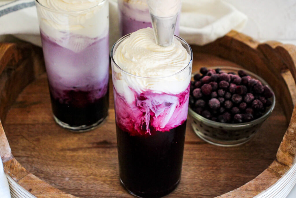 topping the sugar free blueberry Italian cream soda with whipped cream
